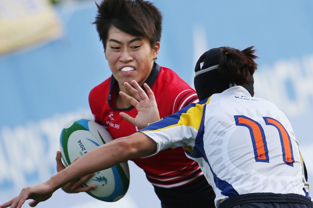 Hong Kong’s Aggie Poon Pak-yan, who came to rugby by way of the national sprint team, fends off a tackle from Liliya Bazyaruk of Kazakhstan during the 2014 Asian Games. Photo: Nora Tam/SCMP