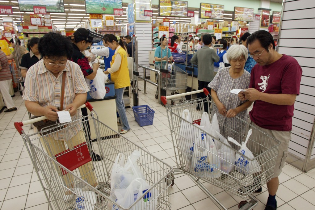 Shoppers pore over their grocery bills in Beijing. Inflation in China edged up a meagre 1.5 per cent as deflation worries linger in the country. Photo: Bloomberg