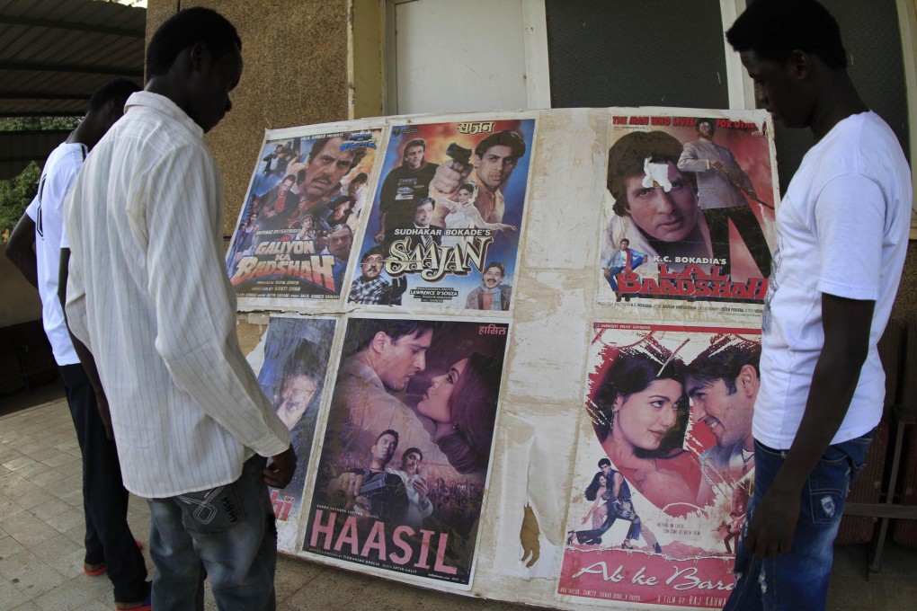 Passersby look at posters advertising films at the Palace of Youth and Children, one of three cinemas still functioning in Khartoum. Photo: AFP