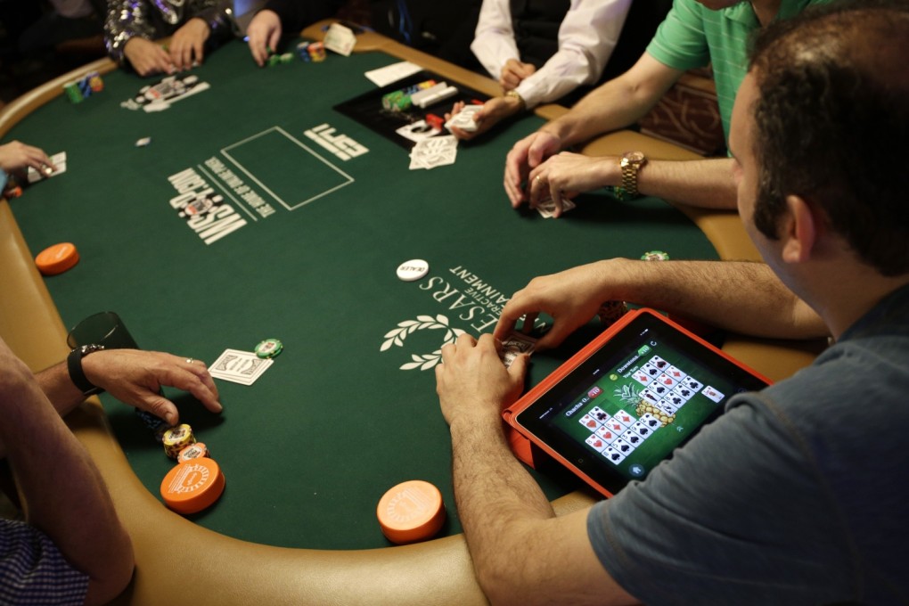 In this July 5, 2014, file photo, Abe Mosseri plays a game on his iPad while also playing Texas Hold 'em on the first day of the World Series of Poker main event in Las Vegas. A computer program that taught itself to play poker has created nearly the best possible strategy for one version of the game. Photo: AP