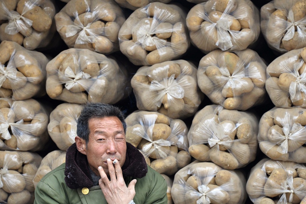A potato seller at a market in Shanxi province in northern China. The crop has a limited use in many Chinese people's diet. Photo: Reuters
