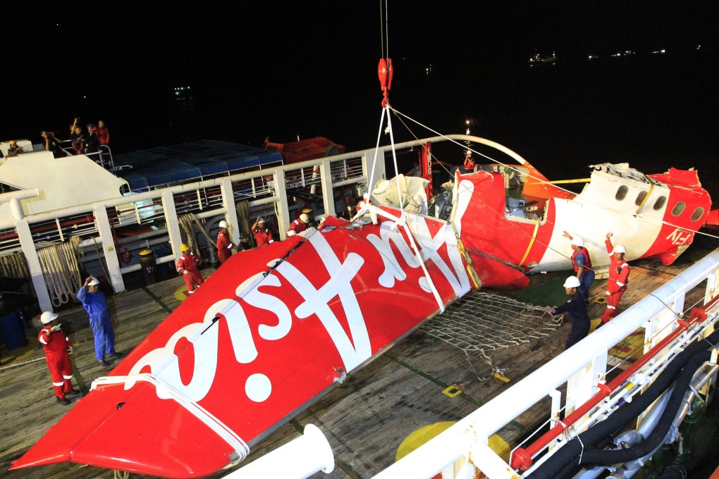 Indonesian national search and rescue agency's crew lifts up the wreckage of AirAsia QZ8501 aircraft tail from the Crest Onyx ship. Photo: EPA