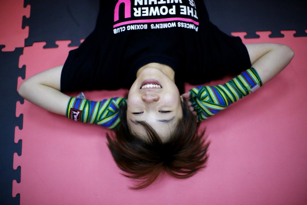 A woman in Shanghai takes a break during a boxing class. Educated young women today are more aware of international norms. Photo: Reuters