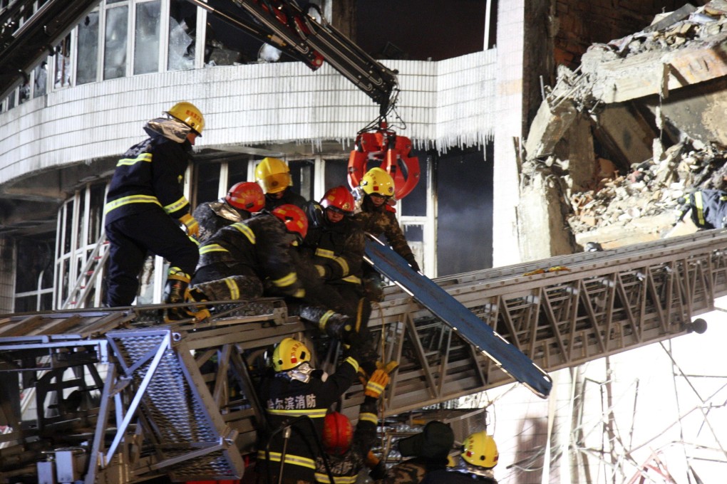 Chinese firefighters battle to rescue a fellow fireman who was buried when a blazing warehouse collapsed on January 2 in Harbin. Photo: Reuters