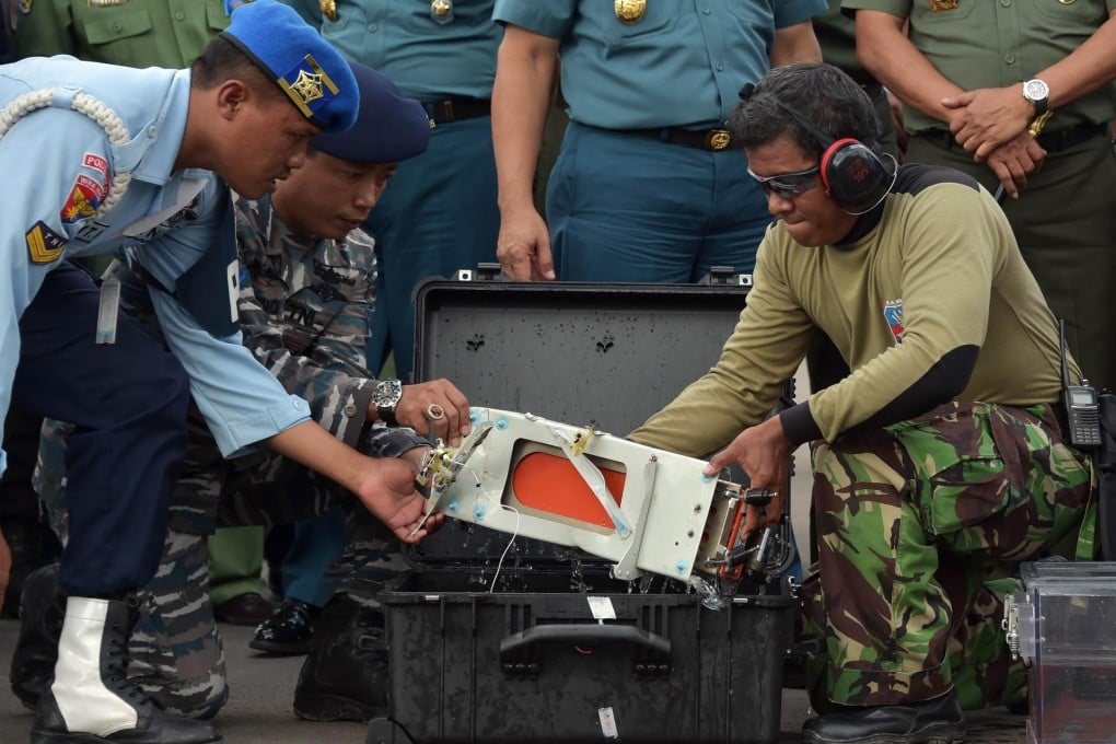 Officers move flight data recorder of the AirAsia plane.Photo: AFP