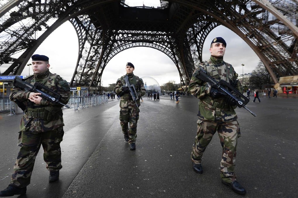 French soldiers, among the 10,000 put on the streets, patrol in front of the Eiffel Tower. Photo: AFP