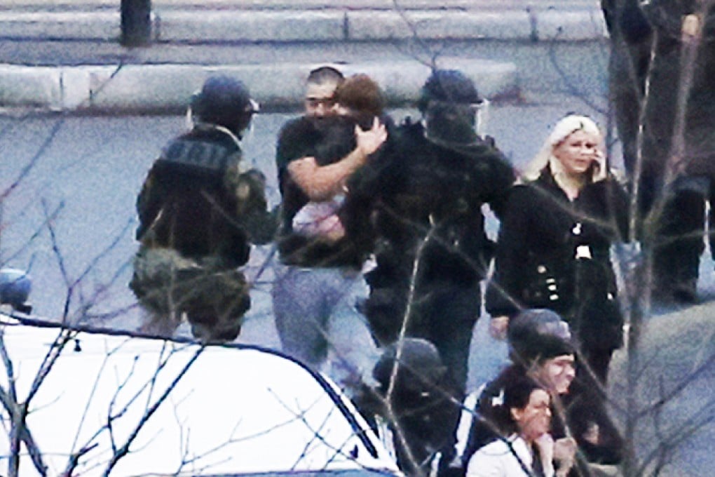 Members of the French police special forces evacuate hostages including a child (centre) after launching the assault at a kosher grocery store in Porte de Vincennes, eastern Paris. Photo: AFP