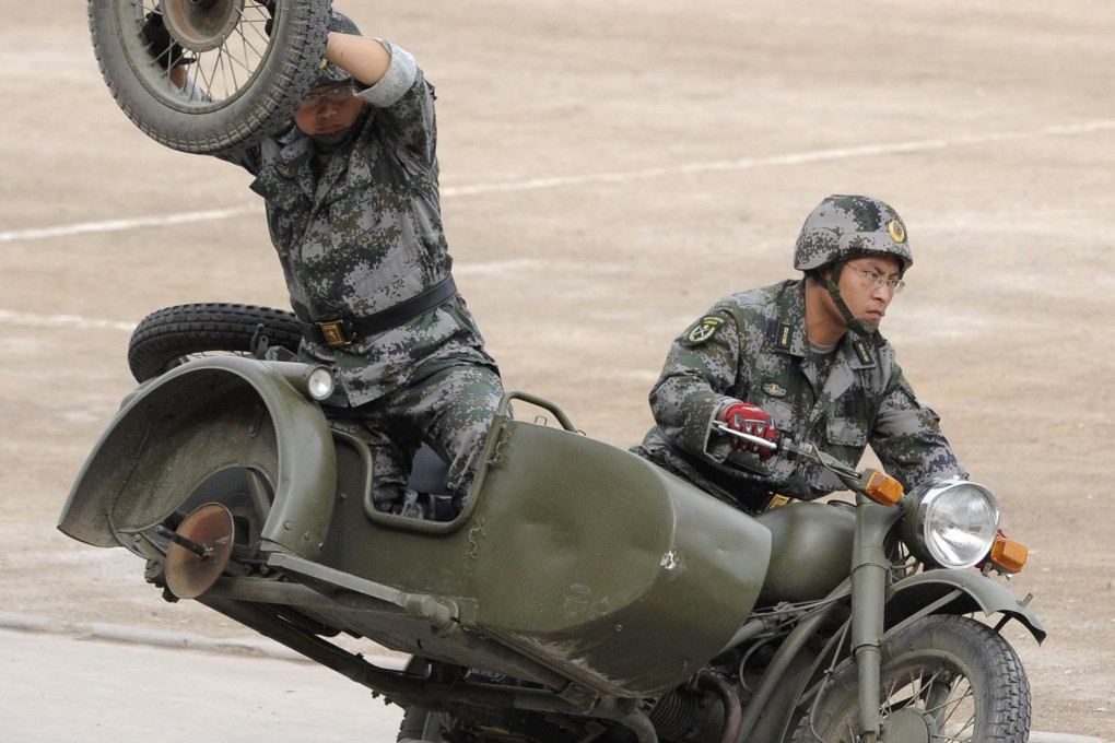 Militia practise a motorcycle stunt during training in Taiyuan, Shanxi province. Photo: Reuters