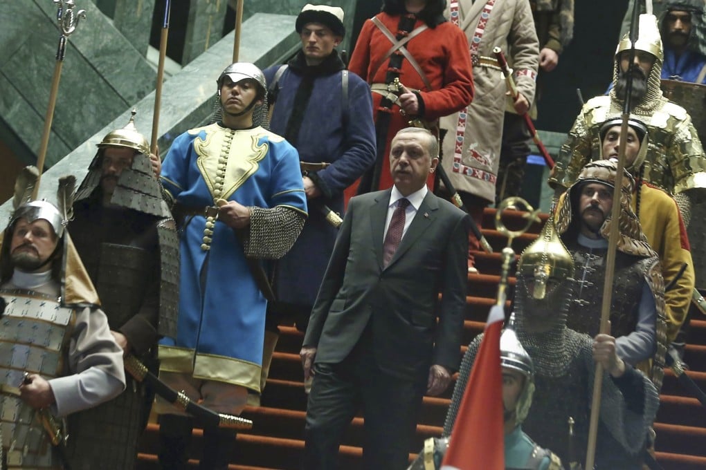 Turkish President Recep Tayyip Erdogan is flanked by honour guards in period costumes during a recent official ceremony. Photo: AP