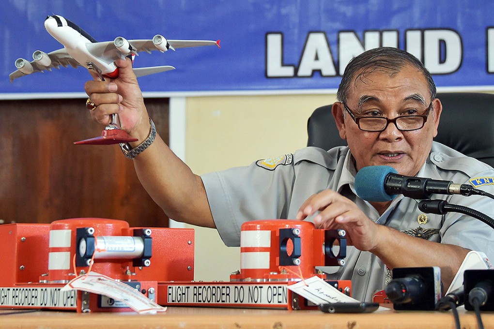 Tatang Kurniadi, the head of the National Transportation Safety Committee shows parts of the flight data recorder (right) and cockpit voice recorder at a press conference in Pangkalan Bun. Photo: AFP