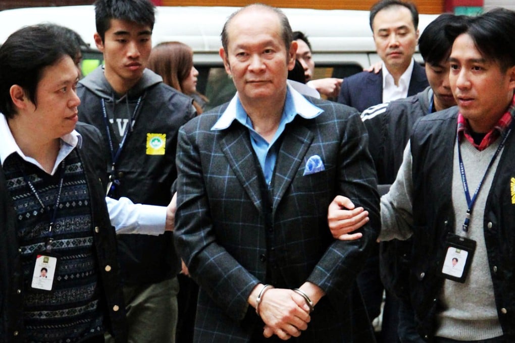 Stanley Ho's nephew, Alan Ho (centre), is led away by police officers in connection with a prostitution case. Photo: SCMP Pictures