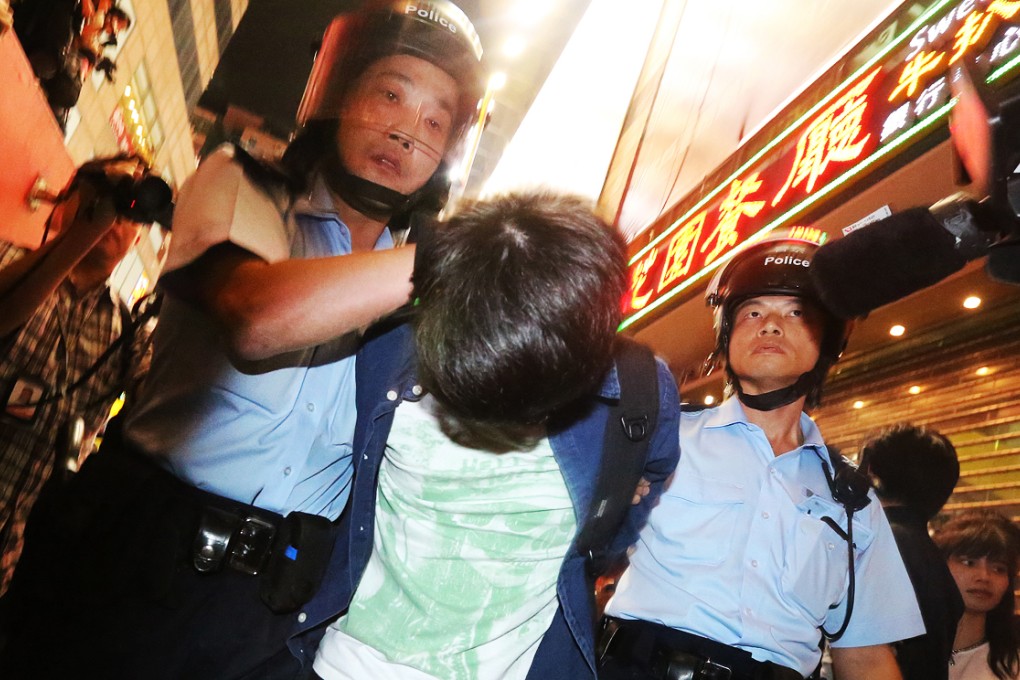 Police officers arrest a young pro-democracy protester in Mong Kok occupied site on November 26, 2014. Photo: Felix Wong
