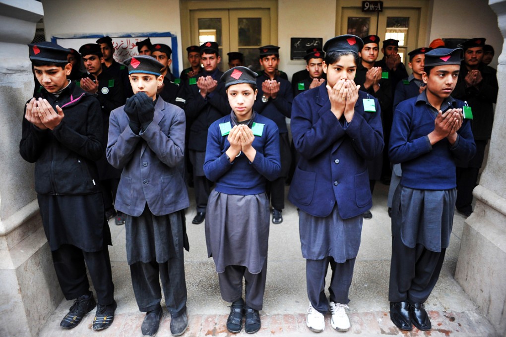 Pakistani students offer prayers as they return to school in northwest Pakistan's Peshawar on Monday. Photo: Xinhua