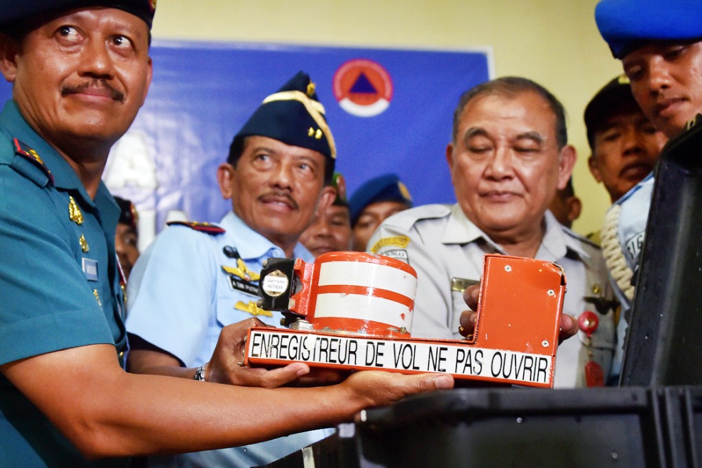 Indonesia's head of the Military Search and Rescue Task Force Widodo (from left), deputy of the Military Search and Rescue Task Force Dwi Kurniadi and Tatang Kurniadi, head of Indonesia's National Transportation Safety committee, hold the cockpit voice recorder from AirAsia flight QZ8501 upon its arrival in Pangkalan Bun. Photo: AFP