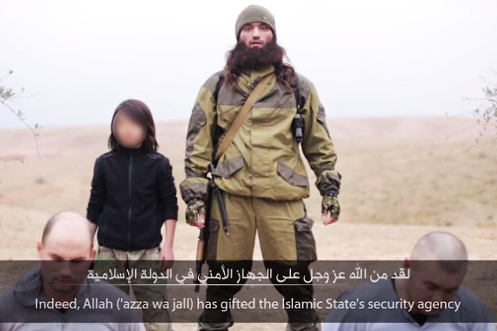 Two men kneel before the boy and a militant before the 'execution'. Photo: SCMP