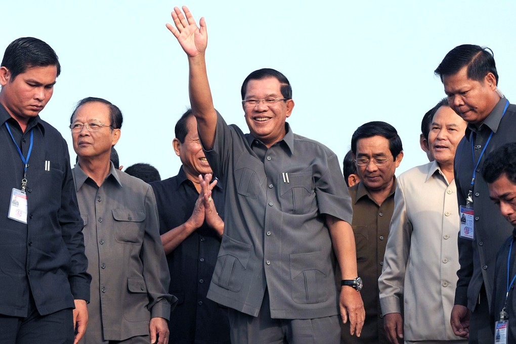 Cambodian Prime Minister Hun Sen (centre) greets people during a ceremony for casting concrete to connect Neak Loeung bridge in Kandal province on January 14, 2014. Photo: AFP