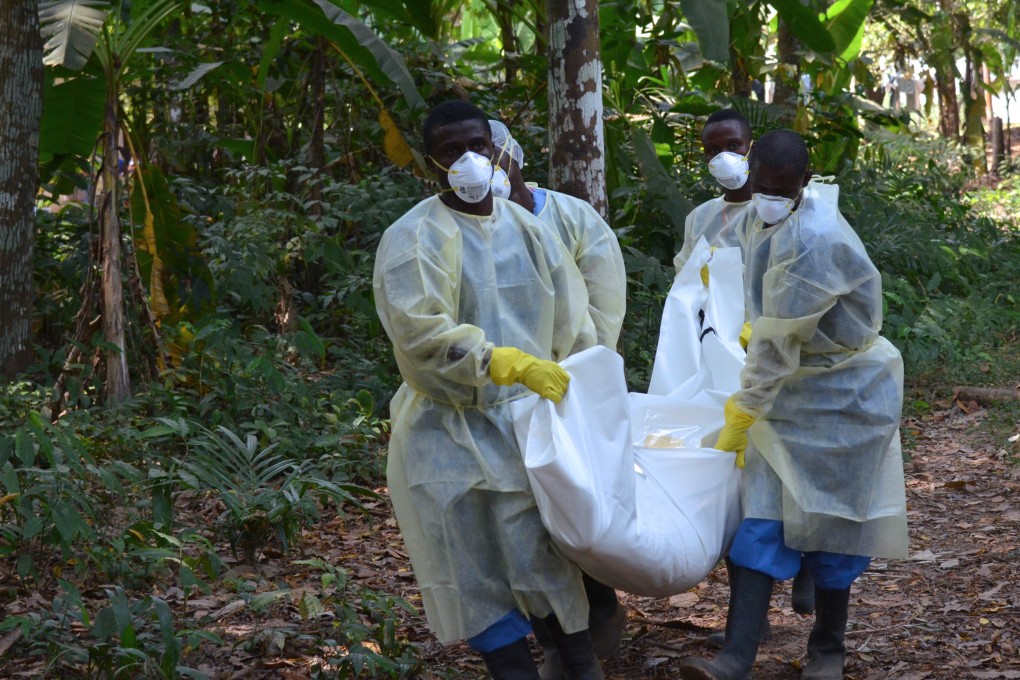 Health workers in Liberia carry the body of a person killed by Ebola. Photo: AFP