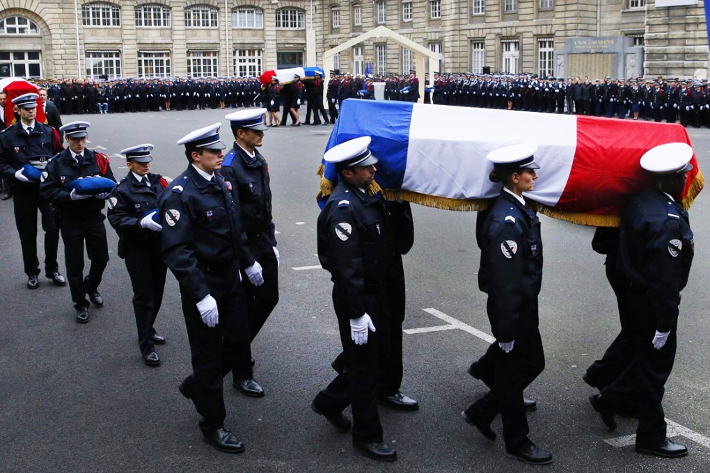 Police officers carry the coffins draped in the French flag of their three colleagues killed in last week's Paris attacks as they were posthumously decorated with the Legion d'honneur at the Invalides Hotel in the French capital yesterday. Photo: Reuters