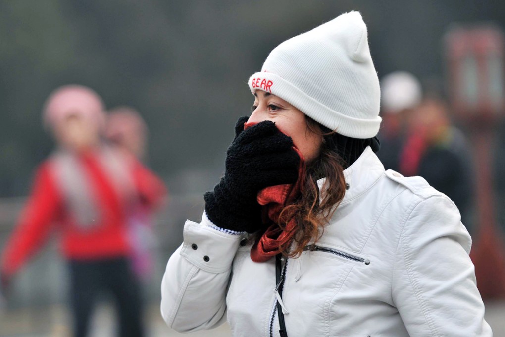 A woman covers her face with a scarf while visiting the Temple of Heaven Park in Beijing. Photo: Xinhua