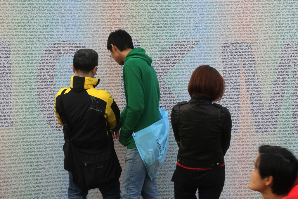 Participants look for their name on the runners' wall during the Standard Chartered Hong Kong Marathon Carnival 2015 in Victoria Park in Causeway Bay. Photos: Edward Wong