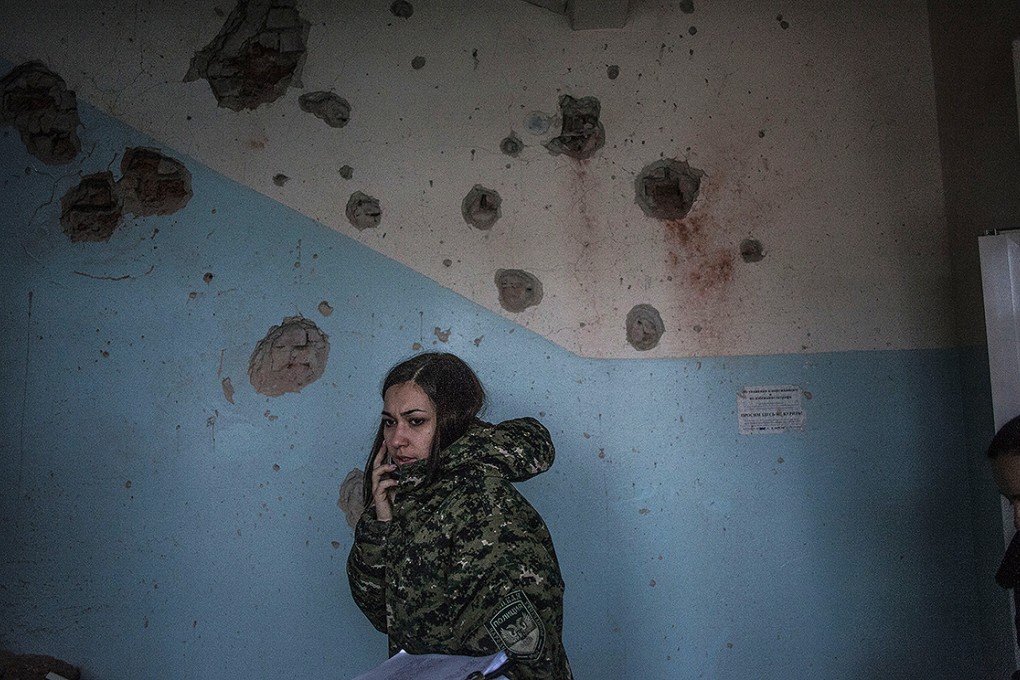 A DNR officer talks on the phone from Hospital No. 3, after it was hit by Ukrainian army artillery in the Kalininsky district of Donetsk. Photo: AP
