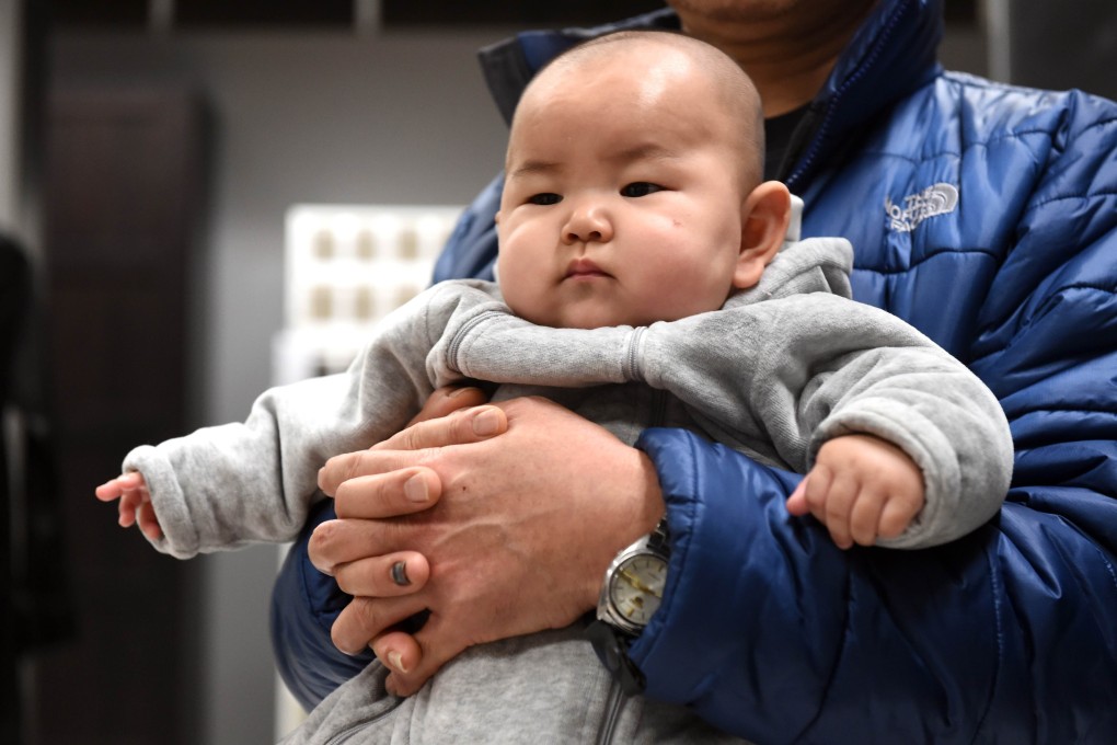 A Chinese baby in the arms of his father at a furniture store in Beijing. Photo: AFP