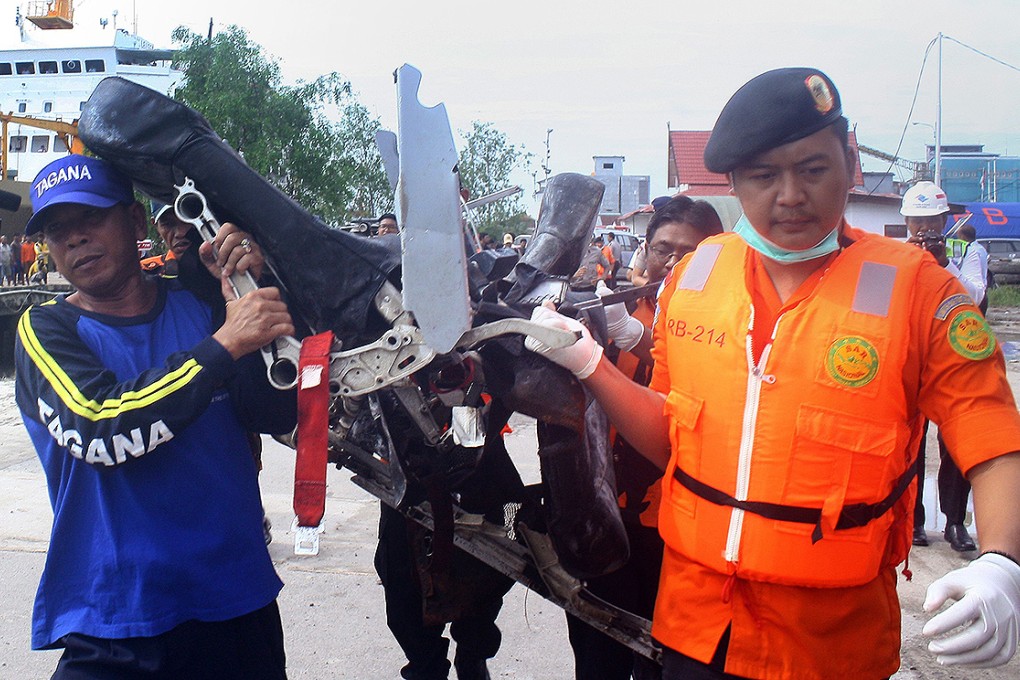 Personnel from Indonesia's national disaster agency carry recovered plane seats from AirAsia flight QZ8501 at the port of Kumai in Central Kalimantan, Borneo. Photo: AFP