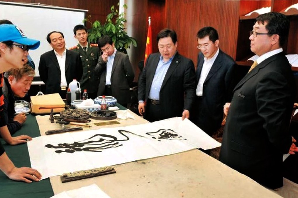 Disgraced former Chongqing police chief Wang Lijun (right) showed off his calligraphy work in 2010.