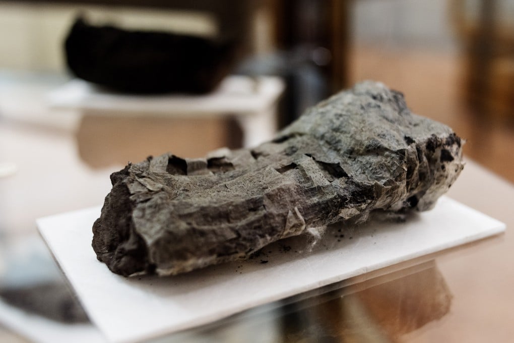 The ancient scroll, completely covered in blazing-hot volcanic material, is displayed at the Naples' National Library, Italy. Photo: AP