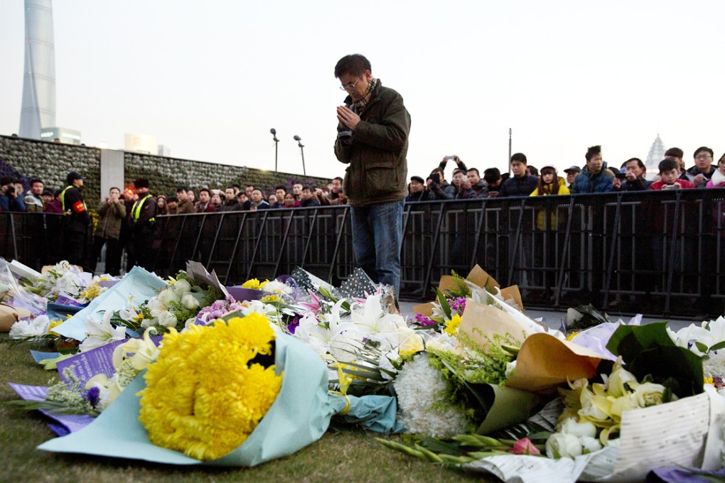 A man lays flowers at the scene of the disaster. Officials have defended the decision to punish only lower-level cadres for negligence. Photo: AP