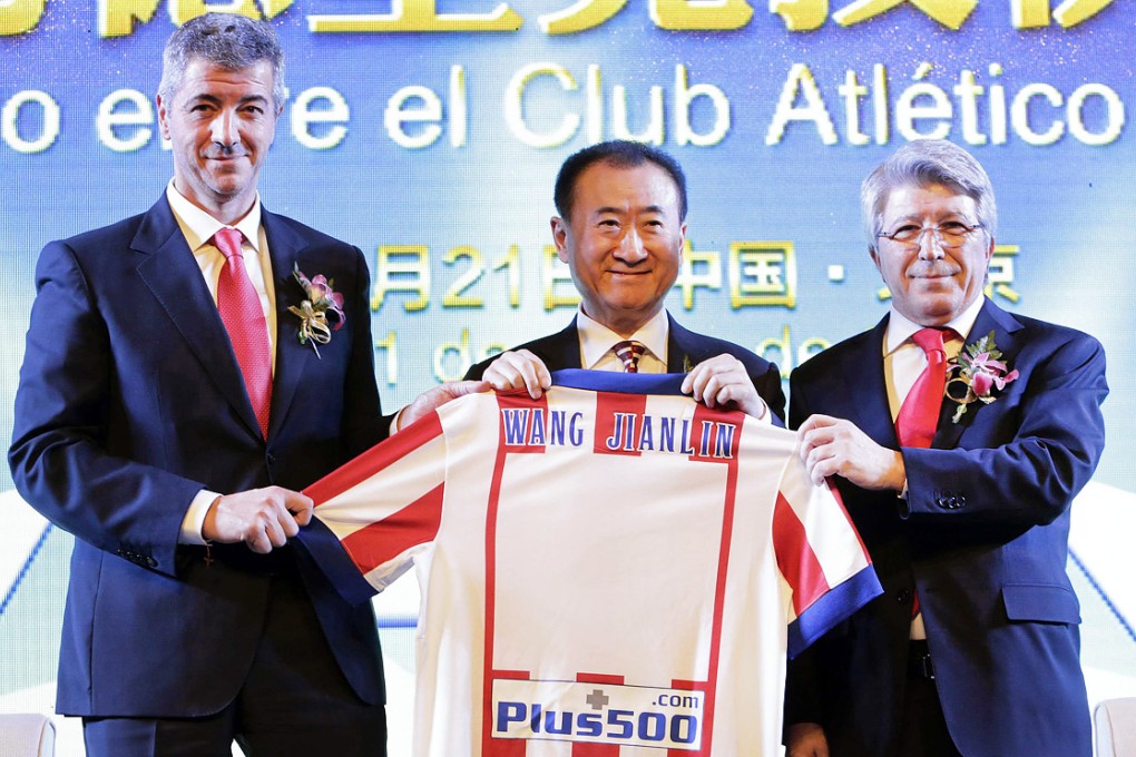 Atletico president Enrique Cerezo (right) and managing director Miguel Angel Gil pose with Wang Jianlin in Beijing. Photo: Reuters