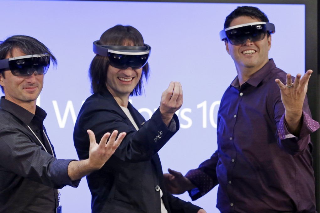 Microsoft's Joe Belfiore, Alex Kipman, and Terry Myerson pose for a photo while wearing "Hololens" devices at the company's headquarters on Wednesday in Redmond, Washington. Photo: AP