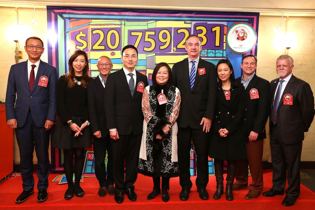 The main guests at the Operation Santa Claus closing ceremony. From left, South China Morning Post editor-in-chief Wang Xiangwei, Operation Santa Claus project director Ellen Yeung, Hong Kong Sanatorium and Hospital deputy medical superintendent Dr Joseph Chan, Director of Broadcasting Roy Tang, Executive Council member Anna Wu, UBS chief communication officer Asia-Pacific Rob Stewart, American International School director of admissions and development Teresa Wong, venue sponsor Greg De'eb of Crown Wine Cellars and Bank of America Merrill Lynch head of global corporate services Asia-Pacific Bob Kee. Photo: Nora Tam