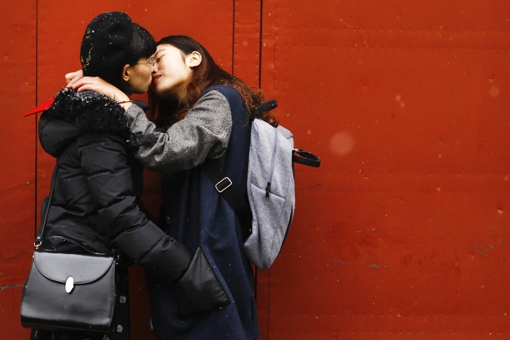 A lesbian Chinese couple kiss for the cameras outside a marriage registry office after being turned away. Some lesbians are opting to marry gay 'beards' to ease social pressure and discrimination. Photo: EPA