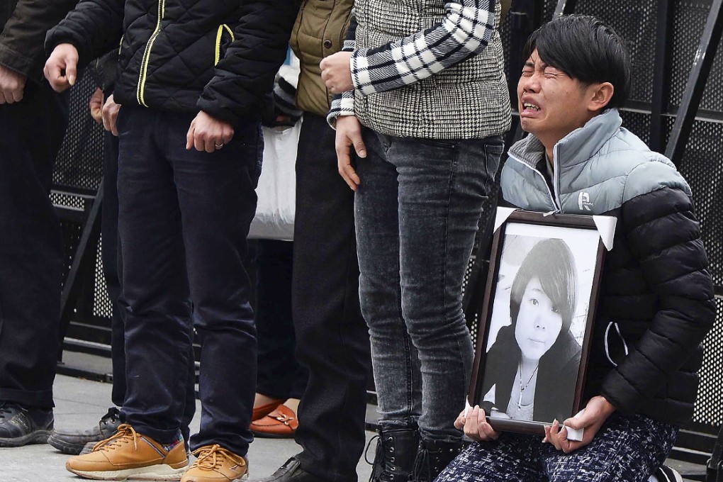 A man holds a portrait of a Shanghai stampede victim. Photo: AP