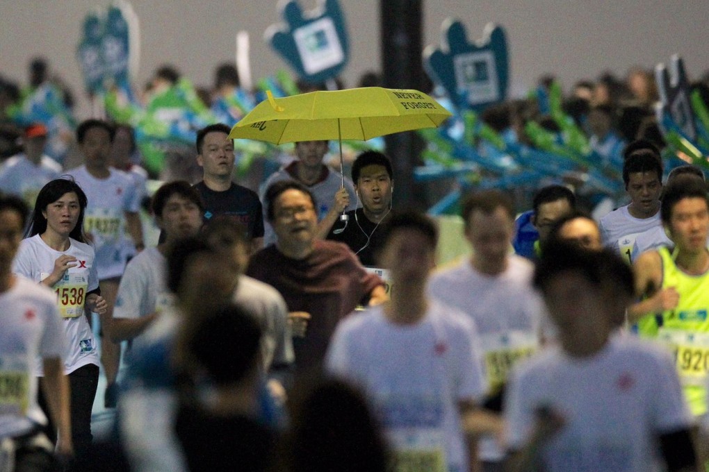 A competitor in the Standard Chartered Hong Kong Marathon shows his support for the Occupy Central democracy movement. Photos: Nora Tam