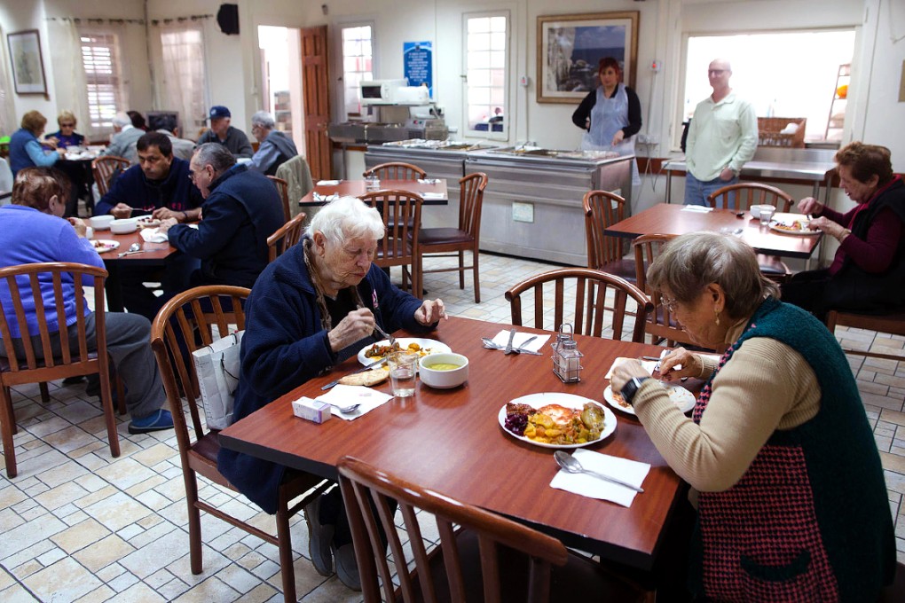 Holocaust survivors eat in the shared dining room. Photo: AFP