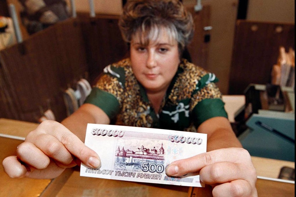 A cashier in a Russian savings bank shows a 500,000 rouble note. Indonesia's experience in the 1997/98 Asian financial crisis should give a lesson to what Moscow can do about the rouble's near free-fall. Photo: AFP