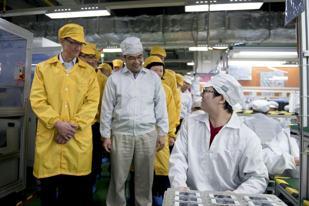 Apple CEO Tim Cook visits an iPhone production line at a Foxconn facility in China in 2012. Foxconn denied reports it is cutting its labour force. Photo: Bloomberg