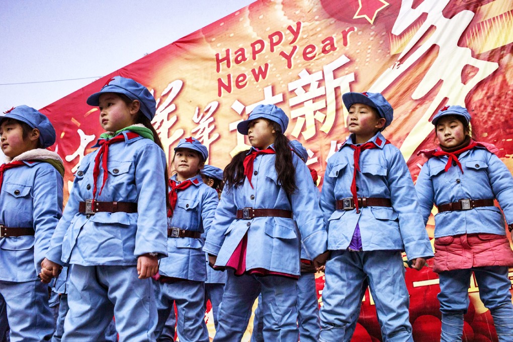 Children in uniform sing after raising the national flag at the Beichuan Red Army elementary school in Beichuan, Sichuan province. Photo: AFP