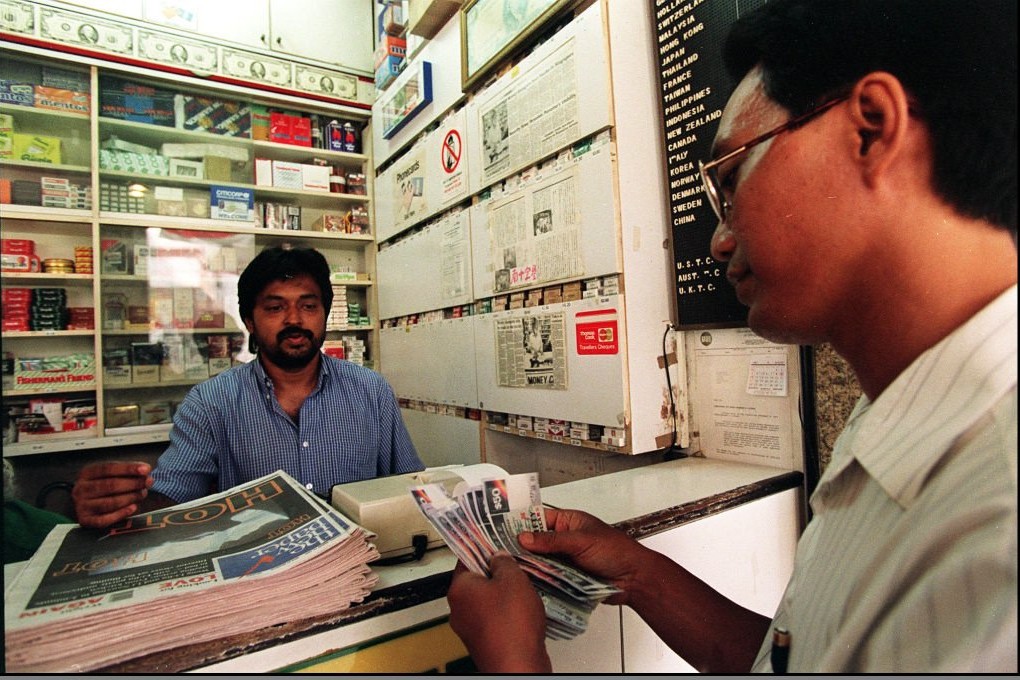 A money exchange dealer counts off Singapore dollars. The Monetary Authority of Singapore unexpectedly announced easing measures to head off deflation and slowing economic growth. Photo: AFP