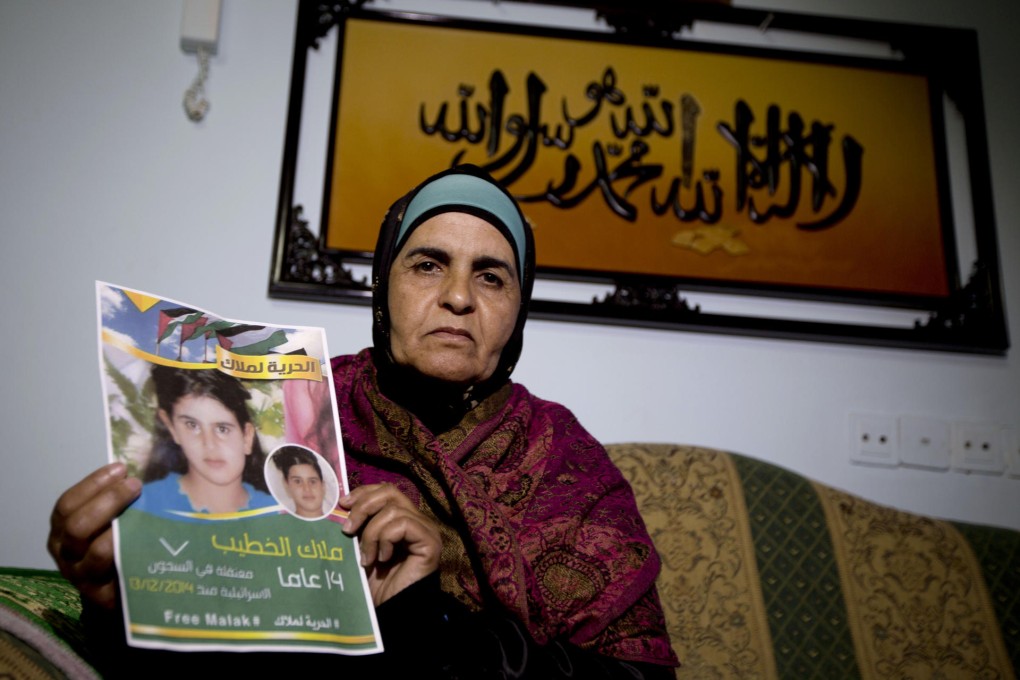 Palestinian Khawla Al-Khatib holds a poster of her 14-year-old daughter Malak al-Khatib, detained for stone-throwing by Israel.Photo: AP