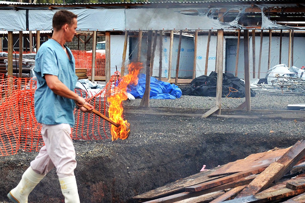 An MSF worker prepares to burn dismantled tents after the first section of the ELWA III Ebola Management Centre in Monrovia was decomissioned. Photo: AFP