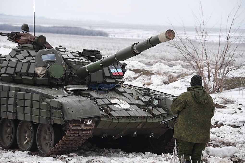 A pro-Russian separatist stands in front of a tank at a checkpoint in Enakieve, 25km from the eastern Ukrainian city of Debaltseve. Photo: AFP