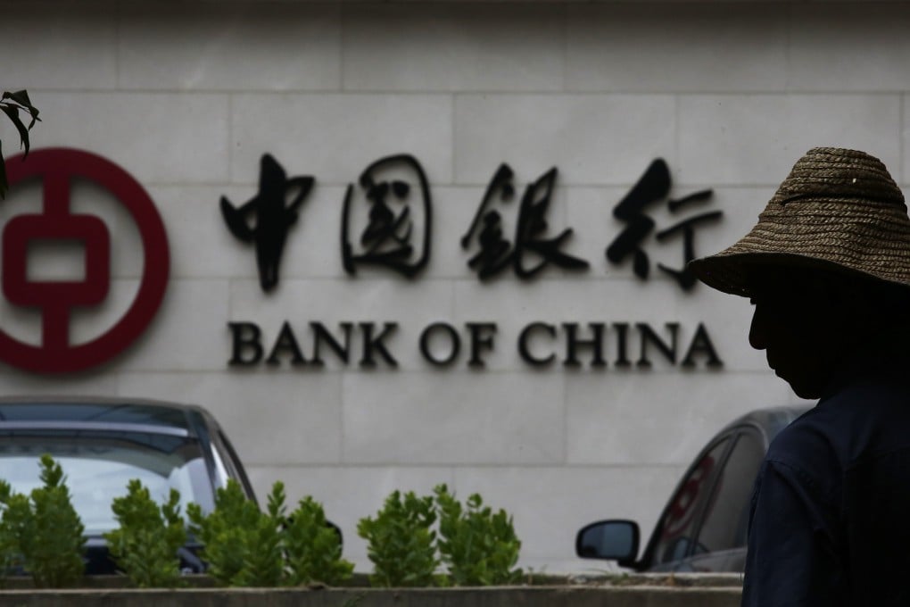 A man silhouetted in front of a Bank of China's logo at its branch office in Beijing. Photo: Reuters