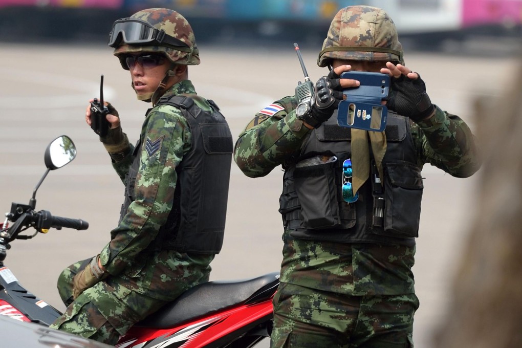 A Thai soldier takes pictures of members of the media, who are feeling more threatened by laws aimed at restricting their work. Photo: AFP