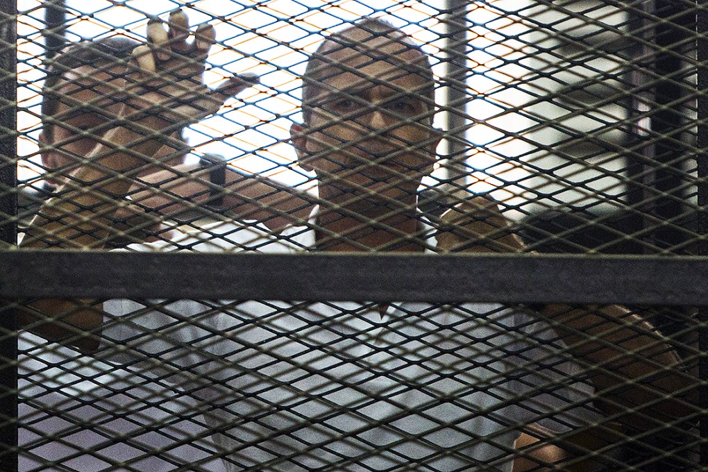 Al-Jazeera's Australian journalist Peter Greste standing behind bars as he listened to the verdict at a court in Cairo. Photo: Xinhua
