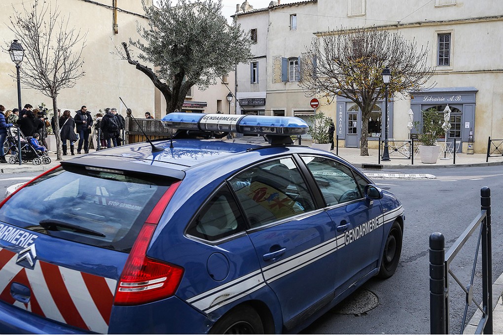 Police officers and members of press stand outside a building in the centre of Lunel, southern France, on January 27. Photo: EPA