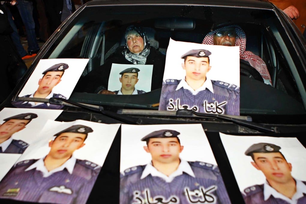 The parents of the captured pilot show the strain as they sit in a car with pictures of their son, Muath al-Kasaesbeh. Photo: AP