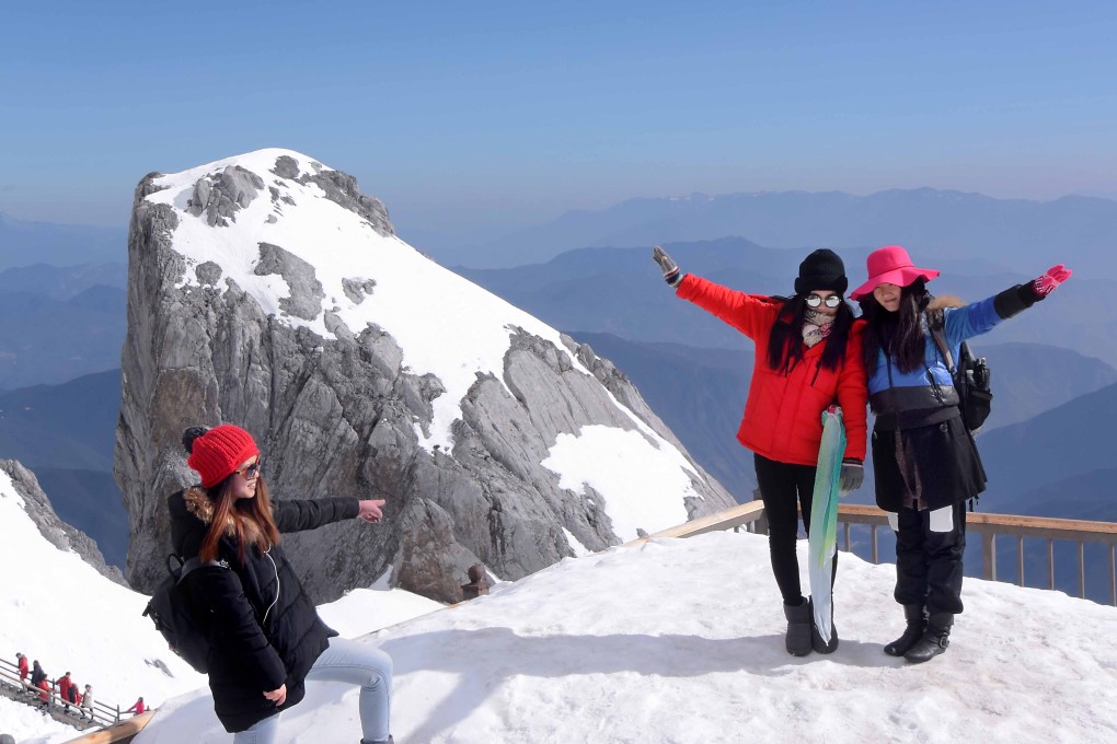 Tourists pose for photos in Lijiang city in Yunnan. With wealth rising, more are heading overseas, but not all hosts are happy. Photo: Bloomberg